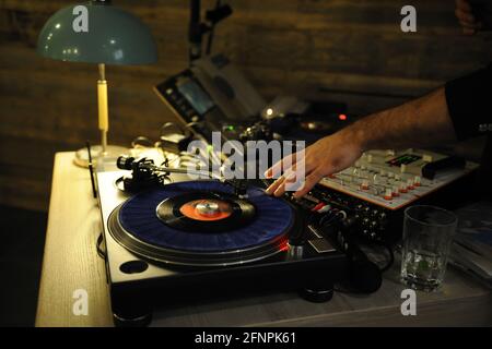 DJ plays live set and mixing music on turntable in the night club. station at club party. DJ mixer controller panel for playing music and partying. Stock Photo