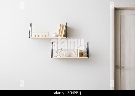 Modern book shelves with decor hanging on light wall Stock Photo