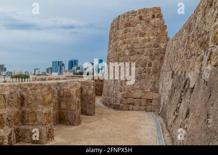 Bahrain Fort Qal'at al-Bahrain and Manama skyline in Bahrain Stock Photo