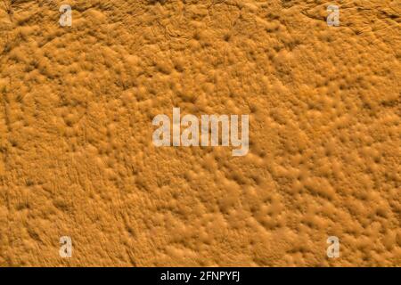 orange sculpturesque plaster with decorative indentation finish wall texture and background Stock Photo