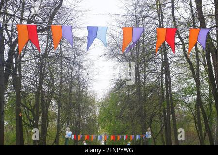 Multi-colored bright flags in front of the entrance to the park Stock Photo
