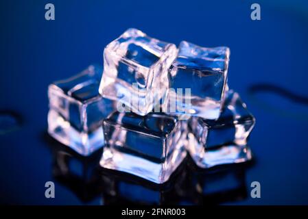 Wet ice cubes on dark blue background Stock Photo