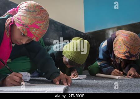 Uttar Pradesh, India. 05-11-2019. Small girls are sitting on the floor participating of the school activities doing their homework. Stock Photo