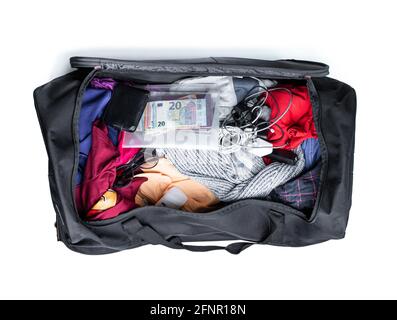 Big suitcase  full of piled travel stuff isolated on white Stock Photo