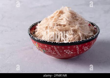 Traditional Turkish cotton candy Pismaniye in ceramic bowl on light gray stone background Stock Photo