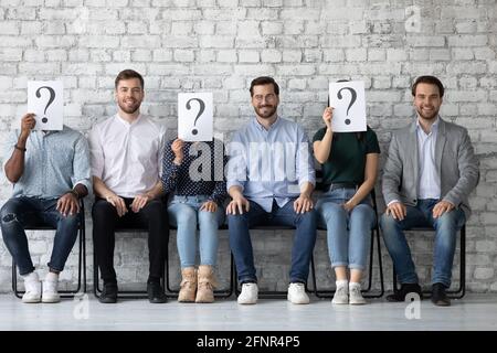 Job candidates sitting on chairs in line Stock Photo