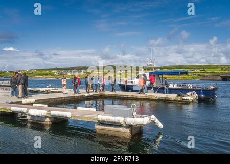 Portmagee, Ireland, August 2019 Group of tourists boarding a cruise boat to visit Skellig Michael island where Star Wars were filmed, Ring of Kerry Stock Photo