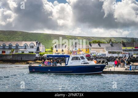 Portmagee, Ireland, August 2019 Group of tourists boarding a cruise boat to visit Skellig Michael island where Star Wars were filmed, Ring of Kerry Stock Photo