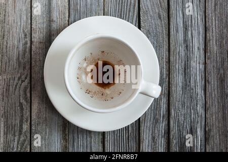 Empty cup with coffee leftovers on wooden table, closeup Stock Photo