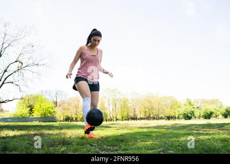 Young female soccer player practicing on field. Stock Photo