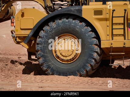 Huge tires on the cab of a Caterpillar 623H wheel-tractor scraper at a road construction site in Santa Fe, New Mexico. Stock Photo