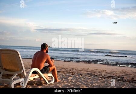 Man flying a drone at Tamarindo, Costa Rica Stock Photo