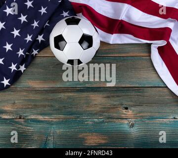 United States flag with soccer ball on faded blue wooden planks for sport concept Stock Photo