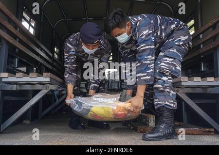 Denpasar, Indonesia. 18th May, 2021. Indonesian Navy officers carry parts of the sunken Indonesian Navy submarine KRI Nanggala-402 after a press conference in Denpasar, Bali, Indonesia, May 18, 2021. The Indonesian Navy, with the assistance of China's People's Liberation Army Navy, has managed to lift a life raft and other fragments belonging to the sunken Indonesian submarine KRI Nanggala-402 in the Bali waters. Credit: Bisinglasi/Xinhua/Alamy Live News Stock Photo