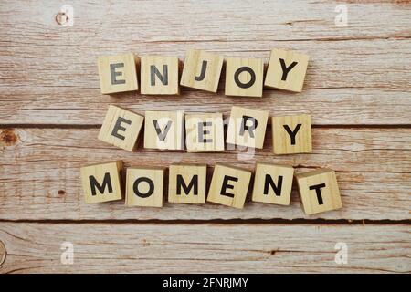 Enjoy Every Moment  alphabet letter on wooden background Stock Photo