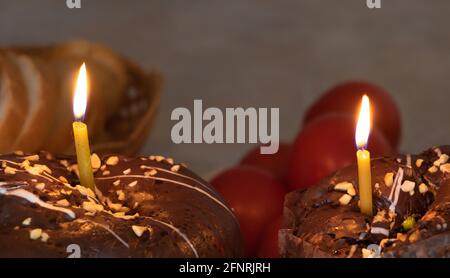 Easter celebration concept - lit candles, easter, and red eggs in the background. Stock Photo
