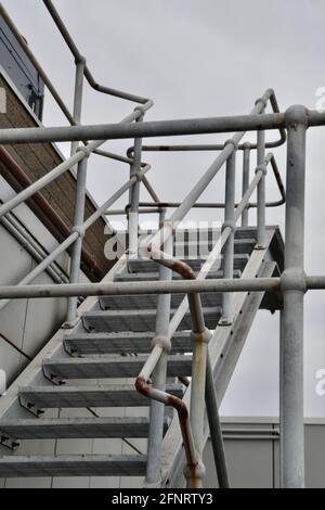 Set of metal or steel safety access steps or stairs on an industrial site leading to a cooling tower Stock Photo