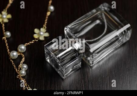 Perfume bottle and gold ornament on wooden background Stock Photo