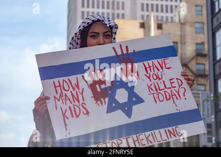 Columbus, United States. 18th May, 2021. A protester sits on top of a car while holding a sign painted like the Israeli flag pointing out the deaths caused by Israel over the past few days. Demonstrators gathered at the Ohio Statehouse to protest against Israel's occupation of Palestine. (Photo by Stephen Zenner/SOPA Images/Sipa USA) Credit: Sipa USA/Alamy Live News Stock Photo