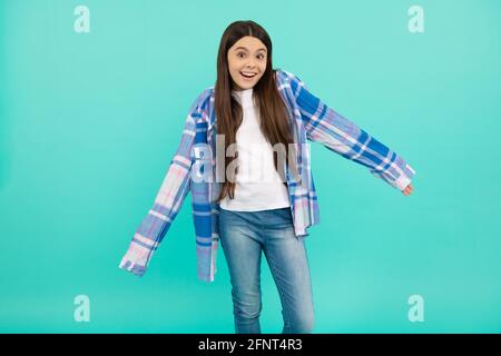 The shirt sleeves are too long. Teenage girl try on plaid shirt. Teenage fashion Stock Photo