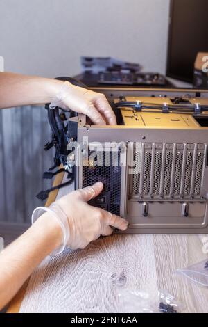 Technician is installing a new power supply into a computer. Stock Photo