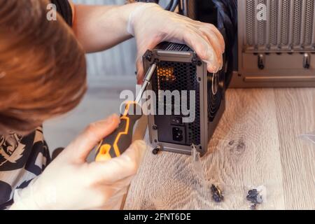 Installing Power Supply Unit into the desktop PC system unit. Computer components. PC assemble Stock Photo