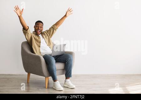 Black Man With Laptop Raising Hands In Joy, Gray Background Stock Photo