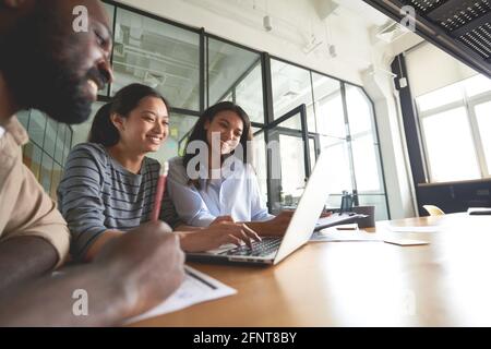 Three friendly coworkers looking at computer screen Stock Photo