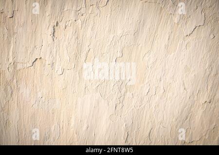 The old wall is milky beige with crumbling plaster. Natural background. Stock Photo