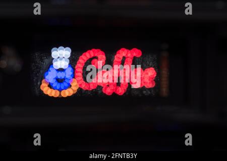 Lighting Red Sign 'COFFEE' and blue symbol of cup with coffee on black night background Stock Photo