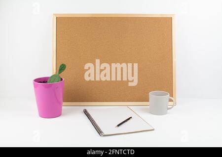 a cork board for notes on white background with pen and notepad in office Stock Photo