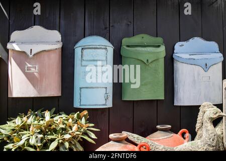 decorative mailboxes hanging on a shabby wall in the garden Stock Photo
