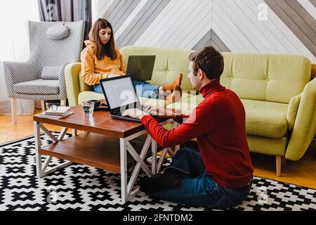 Young couple working at home in the living room. Stock Photo