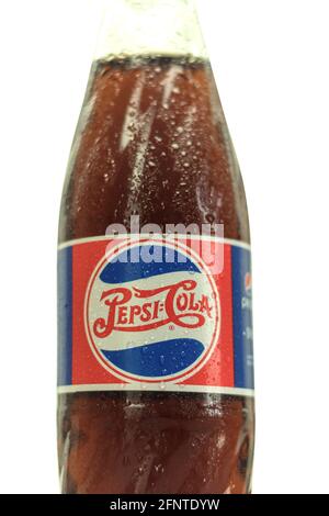 Warsaw, Poland - May 19, 2021: Glass bottle of Pepsi - Cola with a cool drink. White isolated background. Blurred bottle of pepsi on dark background w Stock Photo