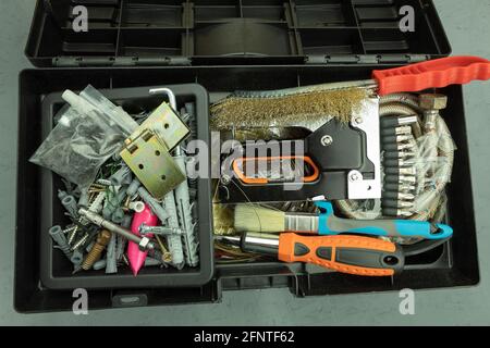 Open large black box for construction tools. Carrying case with many tools on gray background Stock Photo
