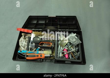 Open large black box for construction tools. Carrying case with many tools on gray background Stock Photo
