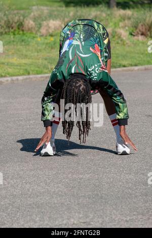 A fit nimble woman in her 50s at a meditative Yoga class in a park in Flushing, Queens, New York City. Stock Photo