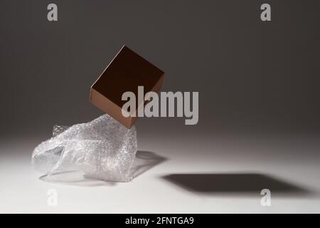 Close-up of cardboard box and bubble wrap on dark background Stock Photo