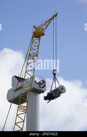 A crawler crane is hoisting the gearbox of a new wind turbine Stock Photo