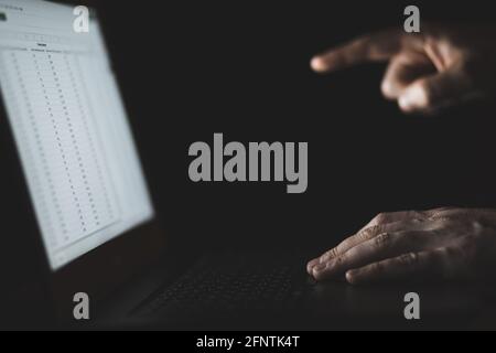 Man type on laptop keyboard. Person points finger on screen. Close up shot of hands and keyboard Stock Photo