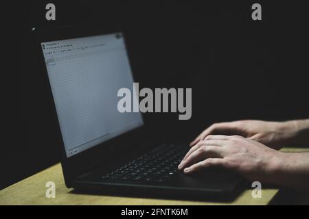 Man type on laptop keyboard. Person points finger on screen. Close up shot of hands and keyboard Stock Photo