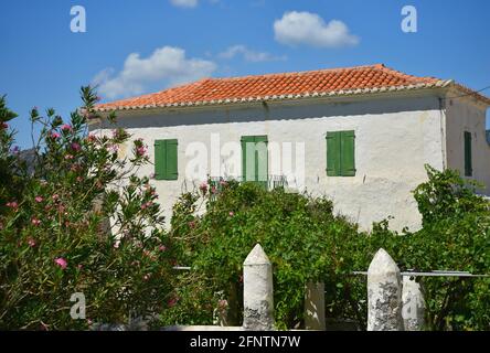 Old rural house with whitewashed walls, green wooden window shutters and a clay tile rooftop in Chora, the capital of Kythira island Attica Greece. Stock Photo