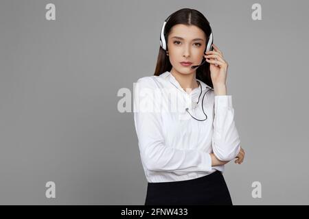 caucasian woman with headset on gray background Stock Photo