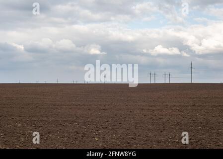 Texan landscape against the backdrop of high voltage towers and cloudy sky. minimalism landscape Stock Photo