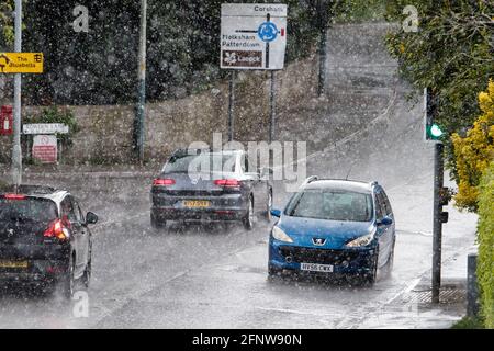 Chippenham, Wiltshire, UK, 19th May, 2021. With forecasters predicting that the weather will become increasingly unsettled for most places in the UK later this week as the heavy rain and strong winds spread across the UK, car drivers are pictured driving in heavy rain in Chippenham as torrential rain showers once again make their way across Southern England. Credit: Lynchpics/Alamy Live News Stock Photo