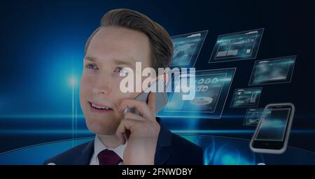 Composition of businessman talking on smartphone over digital screens with data processing Stock Photo