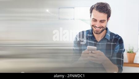 Composition of smiling man using smartphone in office with blurred overlay Stock Photo