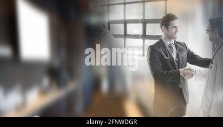 Composition of two smiling male doctors shaking hands in office with double exposure Stock Photo
