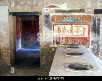 Bar area which served both food and drink. The marble counter has jars inset into the worktop which were  used to hold food. Casa e Thermopolium di Vetutius Placidus (thermopolium and house of Vetutius Placidus) - Pompeii archaeological site, Italy Stock Photo