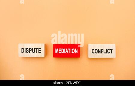 Wooden blocks with the word dispute, mediation, conflict. Settlement of disputes by mediation. Dispute Resolution. Third party, intermediary. Stock Photo